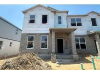 New construction home with visible framework, windows, and a concrete block base awaits its finishing touches at 15370 Burgtheater Dr, Winter Garden, FL 34787