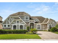 Charming two-story home showcasing a blend of stone and siding accents and a well-manicured lawn at 16108 Bristol Lake Cir, Orlando, FL 32828