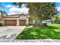 Well-maintained home featuring a three-car garage, lush landscaping, and inviting curb appeal at 1657 Tennyson Ct, Lake Mary, FL 32746