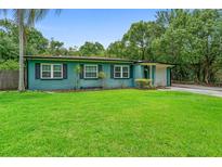 Bright one-story home boasts a green lawn, lush foliage, and attached garage at 1805 Paloma Ave, Sanford, FL 32771