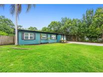 Charming single-story home with a vibrant blue exterior and a well-manicured front lawn at 1805 Paloma Ave, Sanford, FL 32771