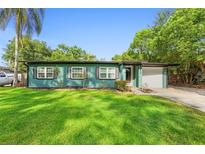 Welcoming home featuring a freshly painted exterior, an attached garage, and lush green lawn at 1805 Paloma Ave, Sanford, FL 32771