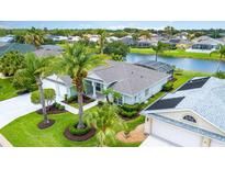 Aerial view of home featuring lush landscaping, picturesque pond, and serene neighborhood at 2135 Springwater Ln, Port Orange, FL 32128
