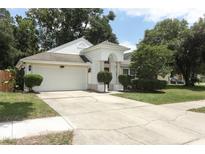 Charming single-story home with a two-car garage and a well-maintained front yard with mature trees and landscaping at 5165 Mystic Point Ct, Orlando, FL 32812