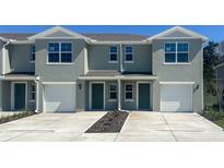 Two-story townhome featuring a one-car garage and manicured landscaping at 6627 Leo Ln, St Cloud, FL 34773