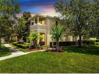 Inviting two-story home featuring a charming balcony and beautifully landscaped front yard at 11937 Bianca Ln, Orlando, FL 32827