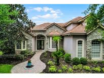 Charming stone and stucco home featuring a beautifully landscaped front yard and tile roof at 1453 Langham Ter, Lake Mary, FL 32746