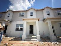 New two-story townhome featuring an open entryway, bright windows, and modern architectural details in a developing neighborhood at 15382 Burgtheater Dr, Winter Garden, FL 34787
