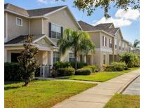 A row of townhomes with well-maintained lawns, sidewalks, and landscaping creates an inviting community feel at 2545 Old Kent Cir, Kissimmee, FL 34758
