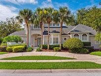 Stunning home with elegant architectural details, mature landscaping, and palm trees at 2880 Old Castle Dr, Winter Park, FL 32792