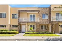 Beautiful two-story townhome features a private balcony, stone accents, and manicured landscaping at 3149 Brasilia Ave, Kissimmee, FL 34747