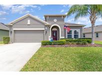 Charming single-story home featuring a well-maintained lawn, arched entryway, and an attached two-car garage at 3349 Sagebrush St, Harmony, FL 34773