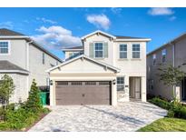 Two-story home features a paved driveway, two-car garage, and neutral exterior paint scheme at 408 Southfield St, Kissimmee, FL 34747