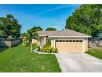 Charming single-story home featuring a well-manicured lawn, inviting front entrance, and attached two car garage at 439 Lake Daisy Dr, Winter Haven, FL 33884
