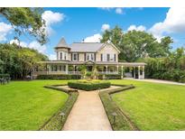 Beautiful two-story home with manicured lawn, mature trees, and a charming walkway with attractive landscaping at 614 Lake Ave, Orlando, FL 32801