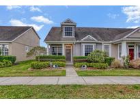 Charming townhome featuring lush landscaping, a welcoming front door, and an eye-catching dormer window at 6527 Silver Queen Way, Windermere, FL 34786