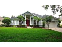 Charming single-Gathering home with a well-manicured lawn, beautiful landscaping, and a striking red front door at 8025 Old Town Dr, Orlando, FL 32819