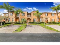 Attractive townhouses boast tropical landscaping, palm trees, brick driveways, and colorful exteriors at 936 Calabria Ave, Davenport, FL 33897