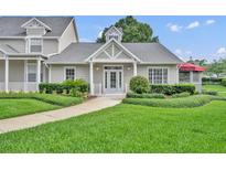 Charming single-story home featuring a well-manicured lawn and inviting front entrance at 104 Nautica Mile Dr, Clermont, FL 34711