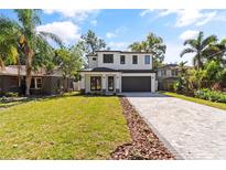 Charming two-story home with a well-manicured lawn and paver driveway at 1217 Cloverlawn Ave, Orlando, FL 32806