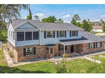 Two-story home featuring brick and siding exterior, a gray roof, dark shutters, and a well-maintained lawn at 1601 Randolph St, Deltona, FL 32725