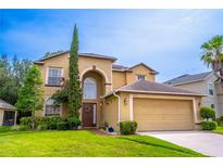 Charming two-story home featuring lush landscaping, arched entry and attached two car garage at 1933 Darlin Cir, Orlando, FL 32820