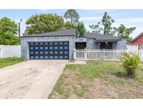 Charming one-story home with blue accent garage door, picket fence and well-maintained front yard at 229 Bitterwood St, Winter Springs, FL 32708