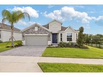 Charming single-Gathering home featuring stone accents, a two-car garage, and a well-manicured front yard at 2500 Raghav Trail Cir, Tavares, FL 32778