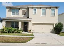 Two-story home featuring a two-car garage, neutral stucco, well manicured landscaping, and decorative shutters at 3074 Royal Tern Dr, Winter Haven, FL 33881