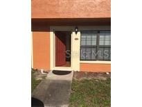 Inviting front entrance with a red door and well-maintained walkway offers a warm welcome to the home at 3318 Amber Wood Way # 100, Winter Park, FL 32792