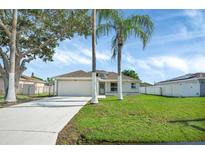 Well-maintained single-story home with lush lawn and two palm trees in front yard at 340 Edgewood Ct, Kissimmee, FL 34759