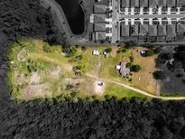 An aerial view of a spacious property with ample land, located near a serene lake and modern homes at 5365 Rambling Rd, St Cloud, FL 34771
