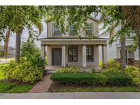 Charming two-story home featuring a welcoming front porch, well-maintained landscaping, and inviting curb appeal at 5911 Grassy Point Rd, Winter Garden, FL 34787