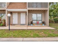 Two-story townhouse exterior with neutral siding, a walkway, and an area for plants at 752 Howland Ln # 114, Altamonte Springs, FL 32701