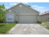 Home exterior with attached two car garage and concrete driveway at 8141 Golden Chickasaw Cir, Orlando, FL 32825