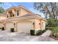 Charming home exterior with two-car garage and well-maintained landscaping at 14 Camino Real Blvd # 14, Howey In The Hills, FL 34737