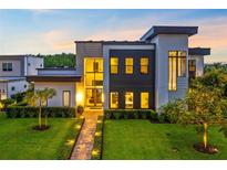 Contemporary two-story home with modern architecture, professional landscaping, and a brick walkway at 14106 Eliot Ave, Orlando, FL 32827