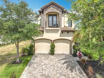 Beautiful two-story home with a two-car garage, balcony, manicured landscaping, and a brick driveway at 16246 Ravenna Ct, Montverde, FL 34756