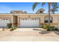 Charming home exterior featuring a two-car garage and well-maintained landscaping at 17404 Chateau Pine Way, Clermont, FL 34711