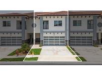 Charming townhouse featuring a garage with glass doors, manicured landscaping, and a stylish modern facade at 2041 Greenbriar Ter, Davenport, FL 33837
