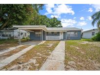 Charming single-story home with a carport and a white picket fence, showcasing its welcoming curb appeal at 2307 Freemason St, Lakeland, FL 33801
