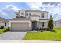 Beautiful two-story home with a two-car garage, stone accents, and well-manicured lawn at 2524 Raghav Trl, Tavares, FL 32778