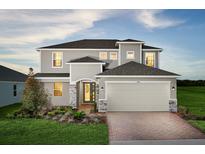 Beautiful two-story home featuring a two-car garage, stylish brick driveway, and beautifully landscaped front yard at 2524 Raghav Trl, Tavares, FL 32778