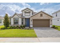 Beautiful single-Gathering home featuring a stone facade, manicured lawn, and a two-car garage at 2530 Raghav Trl, Tavares, FL 32778