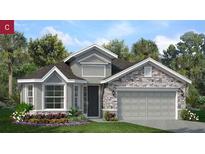 Charming single-story home featuring a stone facade, a two-car garage, and lush landscaping at 3114 Suraj Cir, Tavares, FL 32778