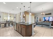 Open-concept kitchen island with bar seating, connected to the living and dining areas at 3847 Shoreside Dr, Kissimmee, FL 34746