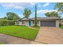 Charming single-story home featuring a well-manicured lawn, a blue front door, and an attached two-car garage at 3902 Brandeis Ave, Orlando, FL 32839