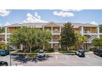 Condo building with parking lot, trees, and multiple balconies at 515 Rum Run # 33515, Davenport, FL 33897