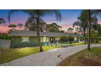 Charming single-story home with fresh green paint, gravel driveway, and tropical landscaping at 530 Lake Bingham Rd, Lake Mary, FL 32746