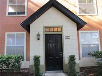 Inviting condo entrance featuring a black front door with a covered porch and well-maintained landscaping at 6021 Westgate Dr # 813, Orlando, FL 32835